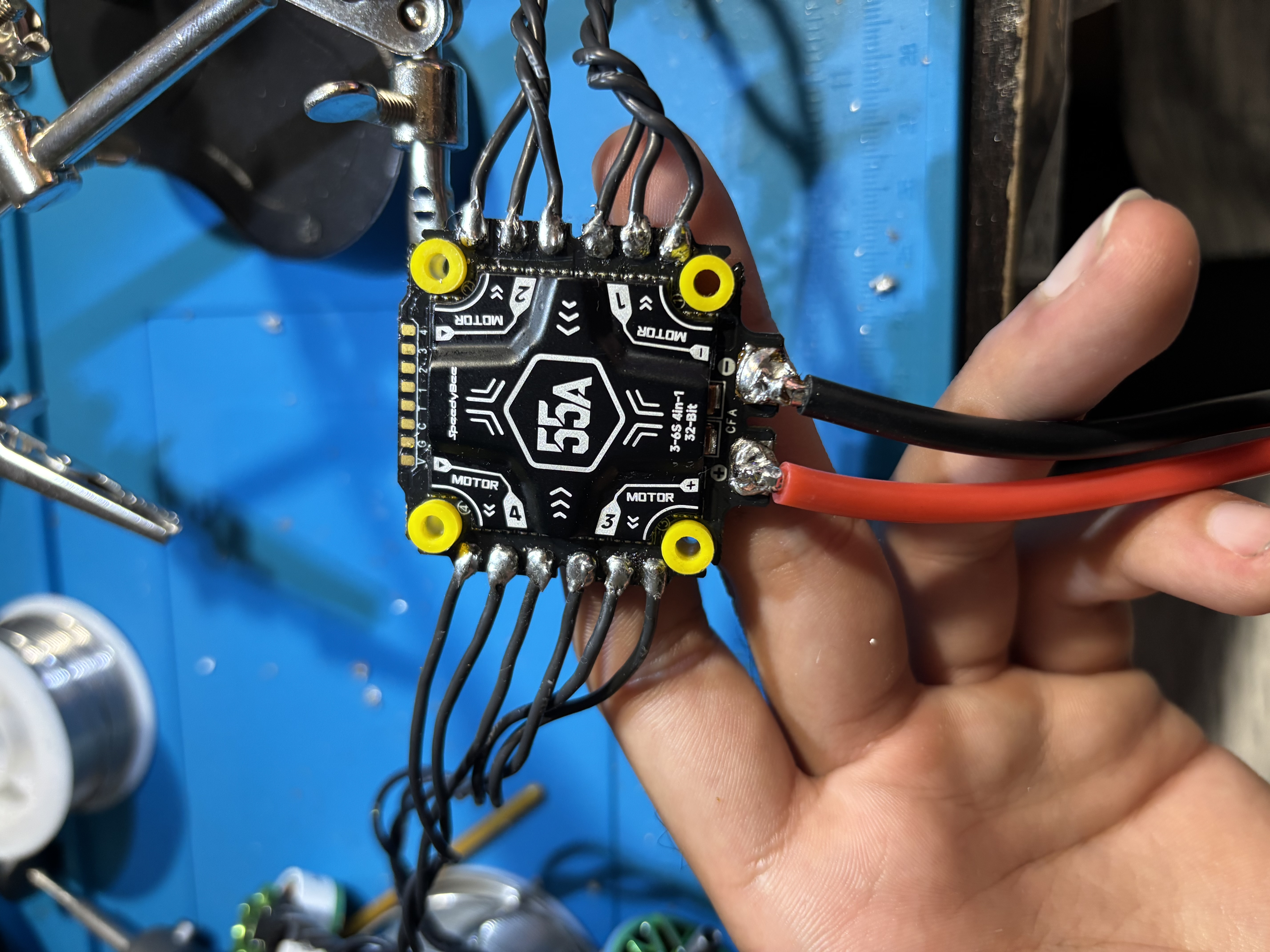 Close-up of the 55A ESC with the four motor phase wires and the thick battery power leads soldered to the pads