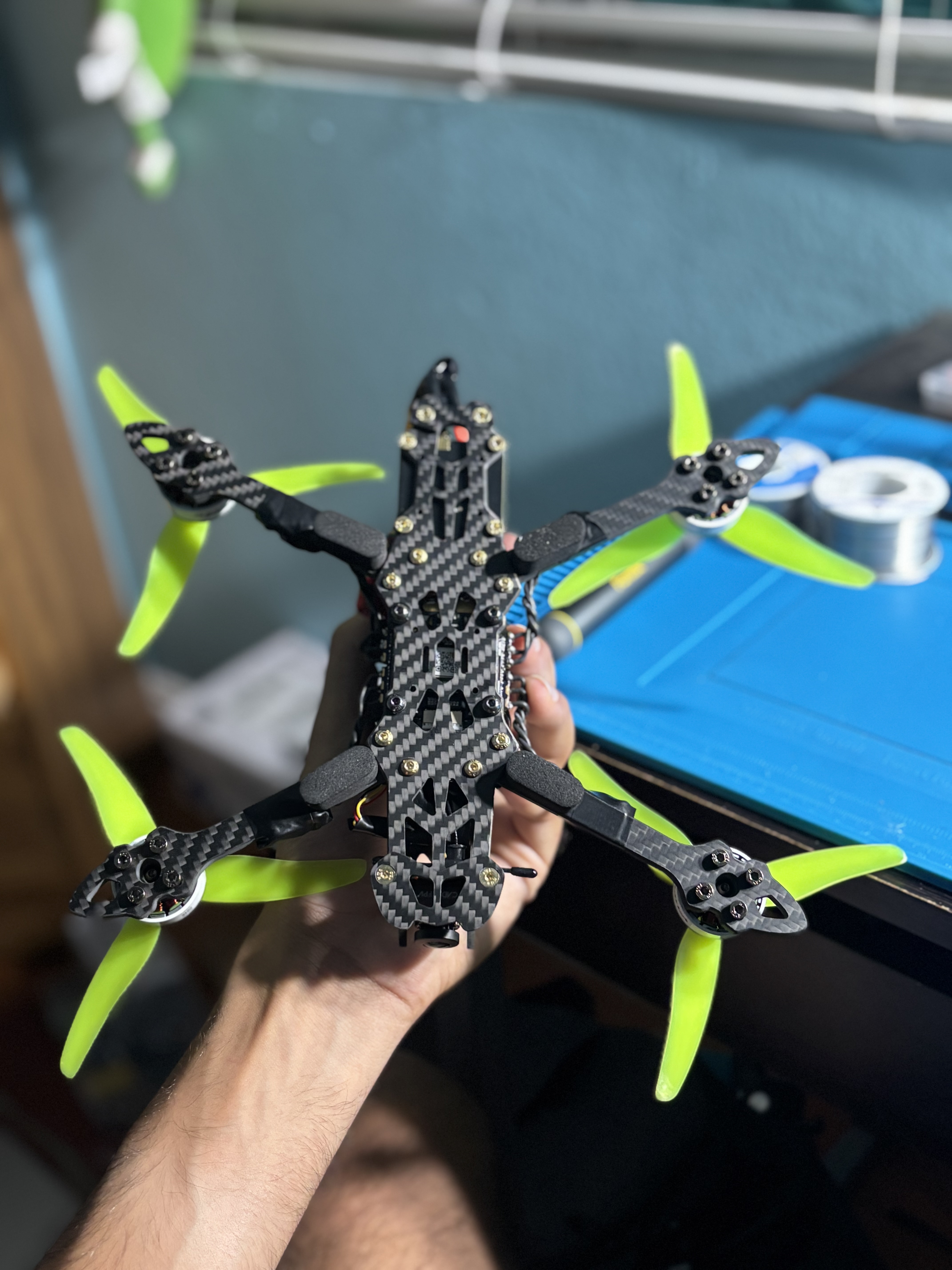 Underside of the assembled Mark4 carbon-fiber FPV frame showing the bottom plate, arms, and mounted motors
